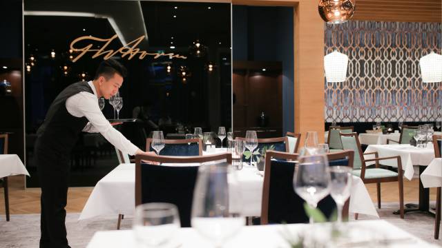 Kellner deckt Tische im Hotelrestaurant ein