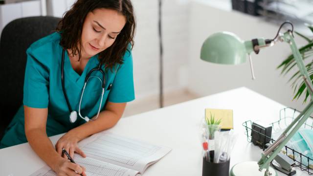 Ärztin schreibt etwas in ein Buch