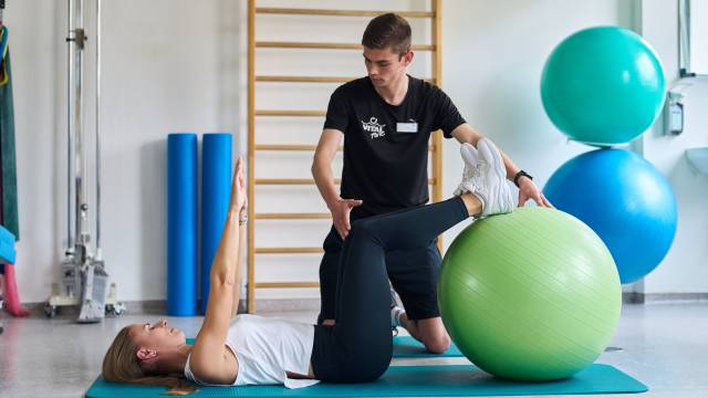 Physiotherapeutisch angeleitete Übung auf einer Trainingsmatte mit Gymnastikball im Gesundheitshotel Hotel am Vitalpark.