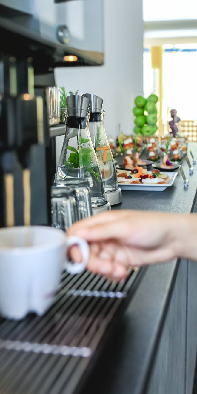 Person lässt sich am Buffet ein Kaffee aus der Maschine