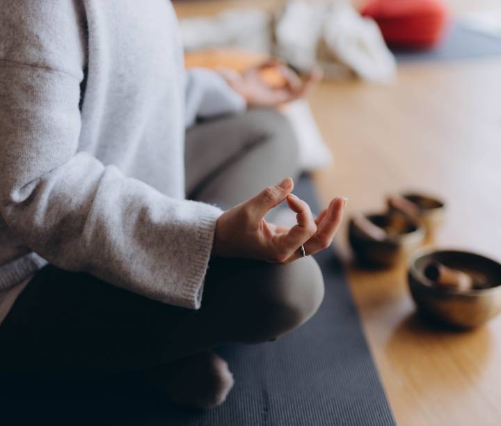 Frau, die Yoga praktiziert mit tibetischer Klangschale.